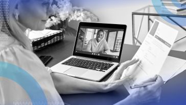 A woman reviews a resume while a man smiles on her laptop display. /remote-recruiting/5-interview-questions-remote-position